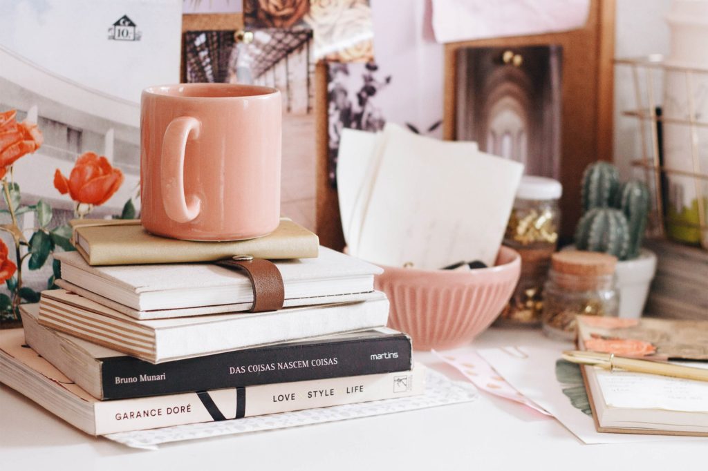 Using Facebook to Market your Writing featured blog image coffee mug on top of a pile of books