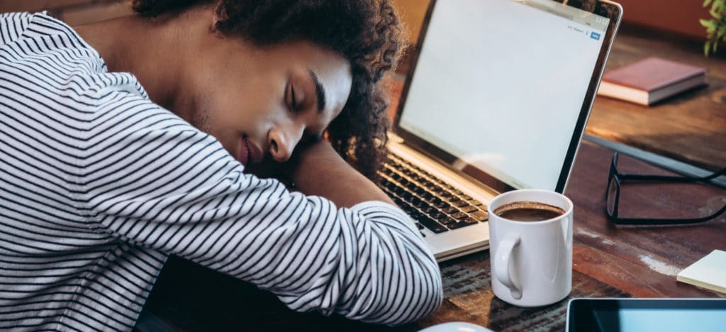 Self-Care for Authors blog featured image person sleeping in front of a laptop