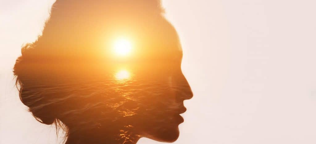 Should You Use a Pseudonym blog featured image woman's silhouette overlay with a sunset