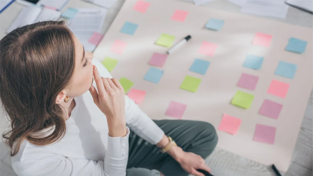 A woman sitting on the floor with sticky notes on her desk for the blog post "How to Pants a novel".
