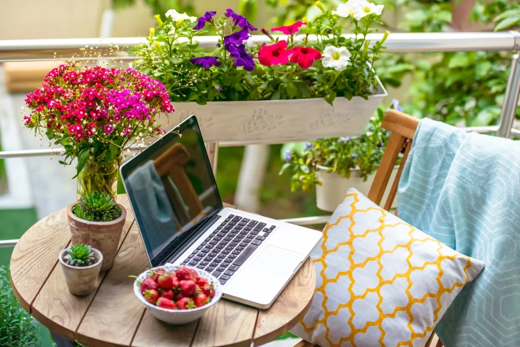 Boost Your Brand with a laptop on a table next to flowers.